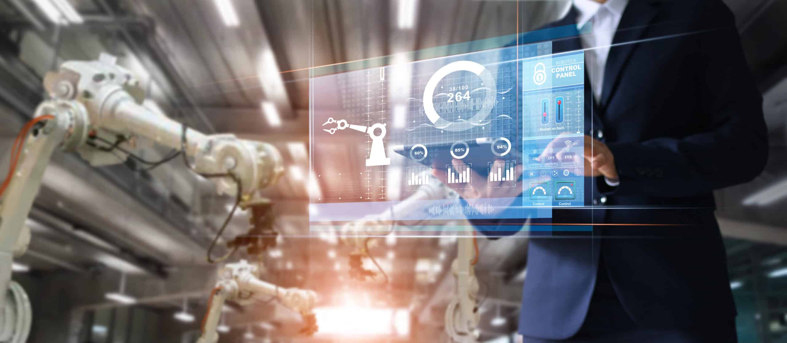 A man holding a tablet in a factory, overseeing industrial operations and monitoring processes.